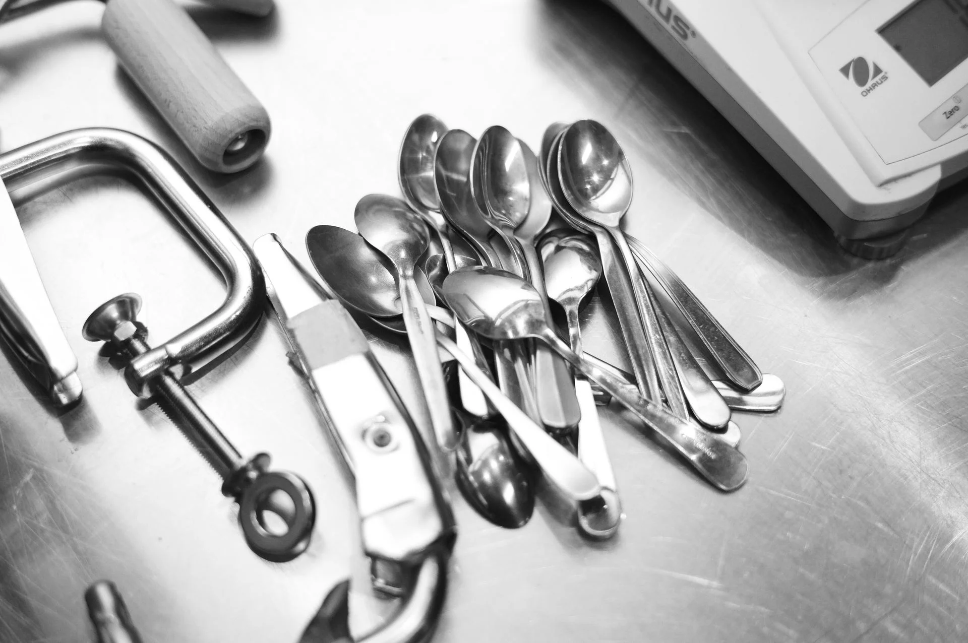 Black and white close-up of kitchen spoons and utensils representing real food solutions for food industrials