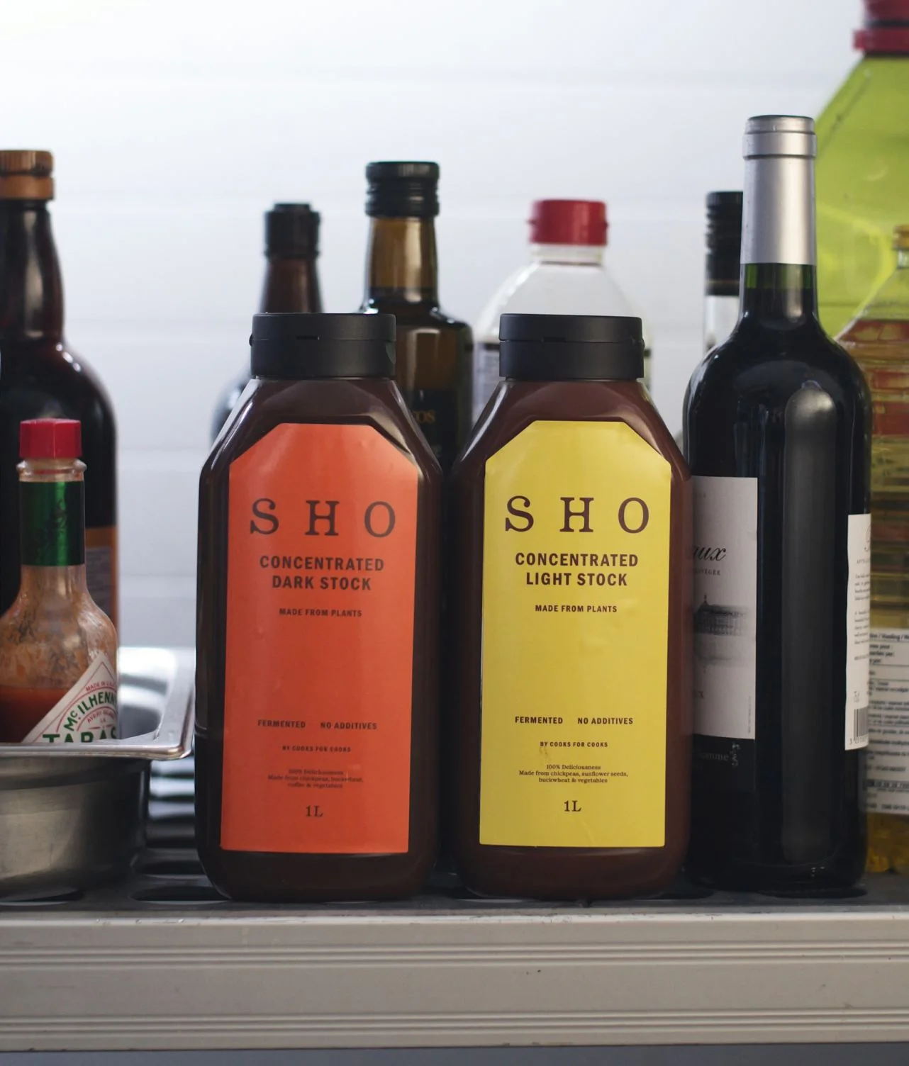Bouteilles SHO dark stock et light stock concentrées sur un plan de travail pour chefs